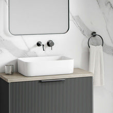 A modern bathroom featuring a freestanding white bath in front of white marble matt bathroom wall panels with soft grey veining. Natural lighting and soft shadows highlight the realistic stone texture of the shower panels, making this a stylish and practical example of shower cladding as a tile alternative